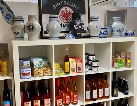 Shelf filled with Frankfurt specialities, including typical stone jugs (Bembel), cider and beef sausage.