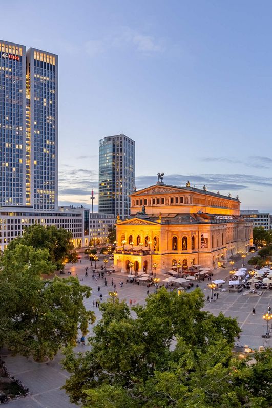 Panoramabild mit Alter Oper, Hochhaus und schönen Altbauten in Abendstimmung.