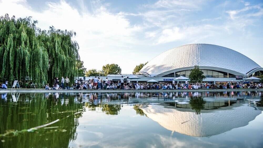 Blick auf die Jahrhunderthalle mit Spiegelung der gesamten Szenerie im Wasser.