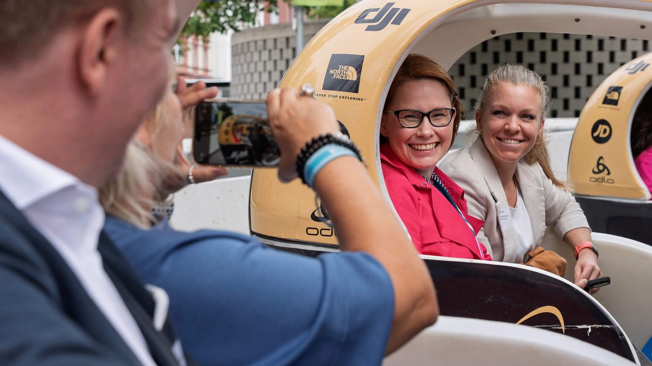 Zwei Personen sitzen in einem Velotaxi.