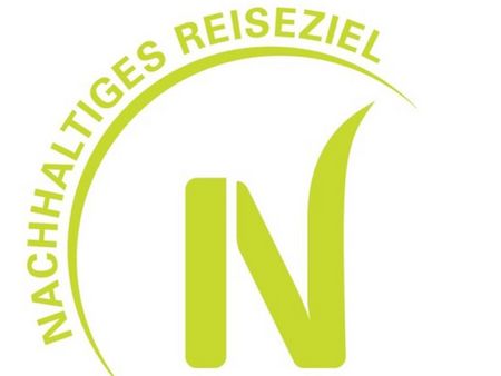 Das Logo des Zertfikats TourCert mit dem Schriftzug Nachhaltiges Reiseziel.