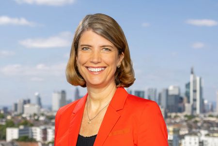 Portrait of Jutta Heinrich in front of the Frankfurt skyline.