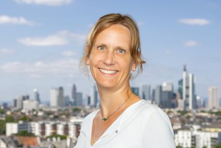 Portrait of Kirsten Bialonski in front of the Frankfurt skyline.